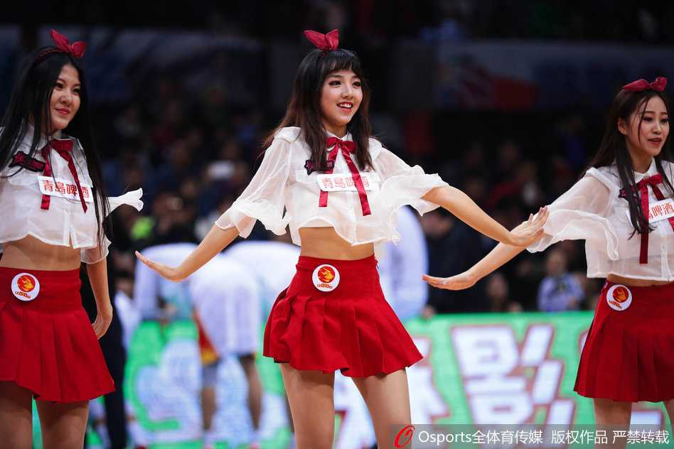 深圳篮球宝贝近景，精致的妆容在汗水映衬下更显光彩照人，她手拿金色花球，面带极具感染力的微笑，专注地进行着表演。