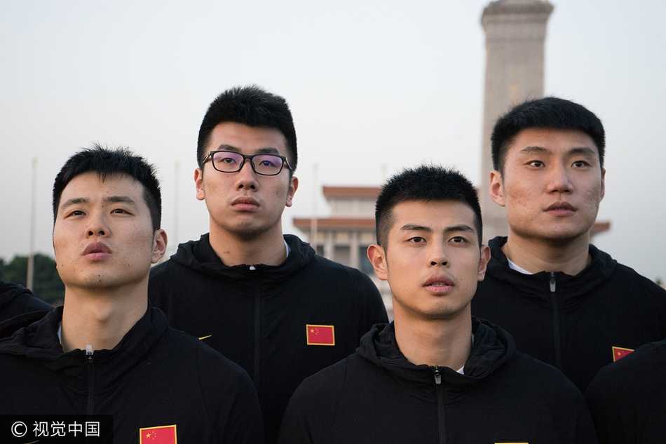 主帅李楠神情专注而严肃，他站在队列中，目光深邃地望向旗杆方向。作为曾经的国家队锋线尖刀，如今转型为“红队”掌舵人，他深知这一刻对这群年轻人的精神洗礼远比一场训练赛更加意义深远。