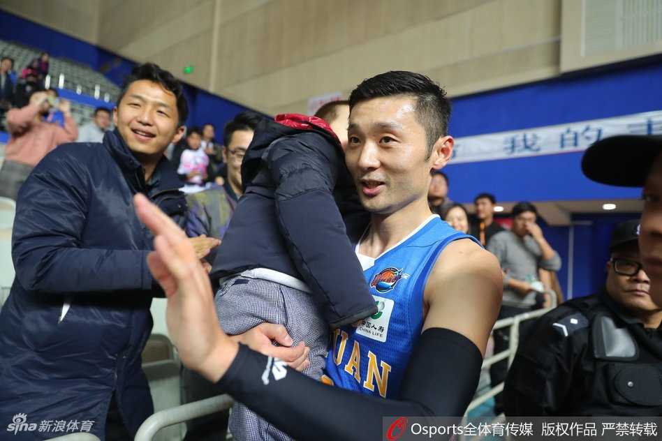 刘炜抱着儿子与热情的小球迷互动，他面带慈爱微笑，耐心签名，这一刻他不仅是球场英雄，更是亲切的邻家大哥