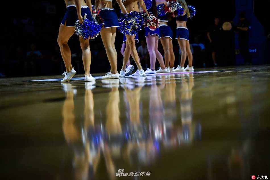 镜头定格在一位笑容灿烂的啦啦队员身上，她手持金色啦啦花球，身姿挺拔，在球场灯光映衬下，一双白皙笔直的铅笔腿格外抢镜，完美诠释了力与美的结合。