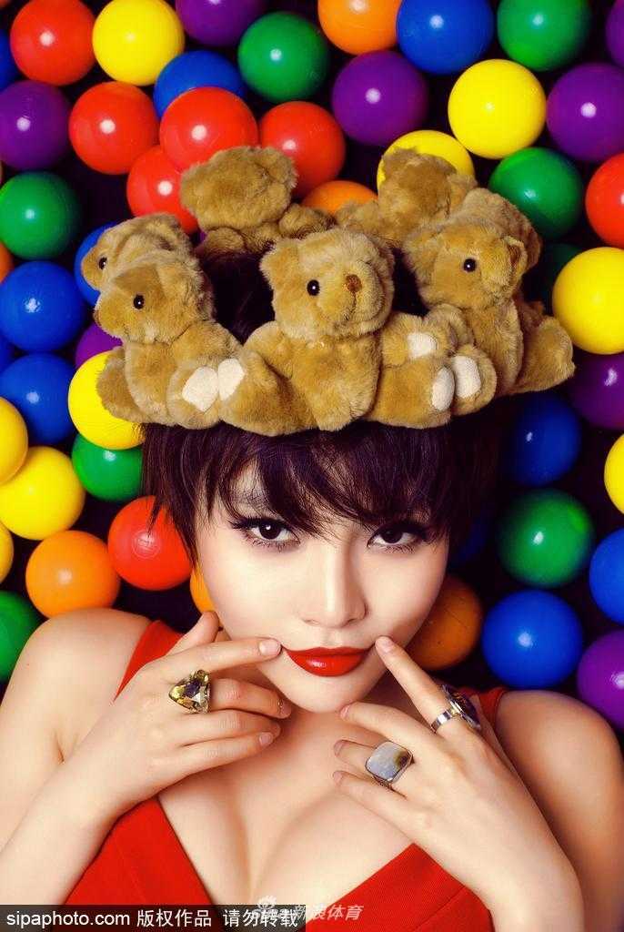 烈焰红唇演绎球场柔情 她侧身而坐,双腿盘起将篮球轻轻放在膝上,目光温柔地望向远方,宛如球场边的一幅静态油画