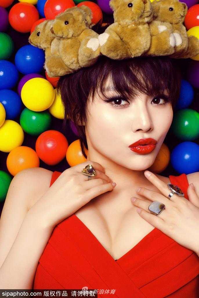 烈焰红唇演绎球场柔情 她单手轻松转着篮球,另一手俏皮地捏着发梢,吐舌一笑,古灵精怪的模样十分惹人喜爱