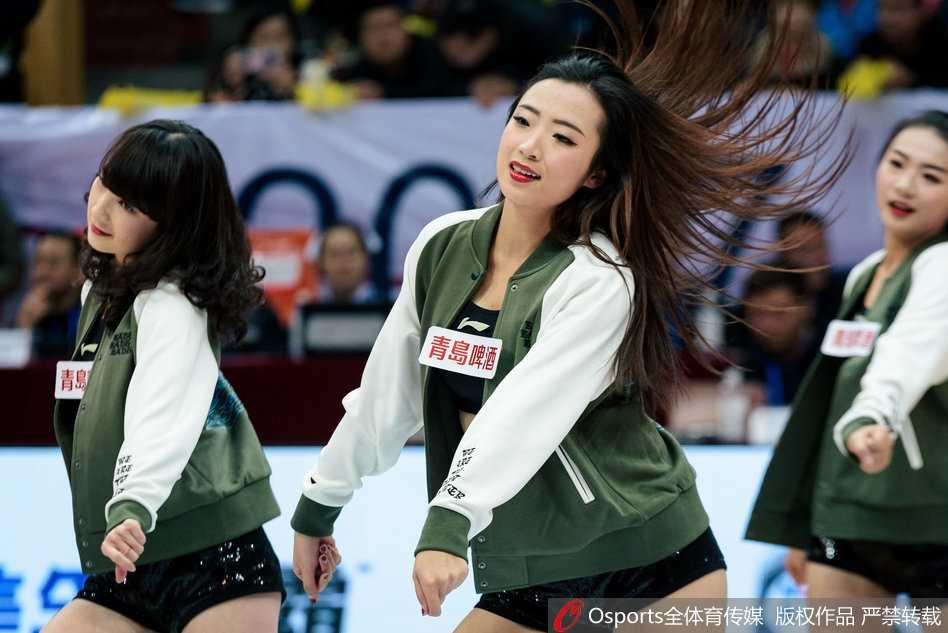 镜头拉近，一位领舞的篮球宝贝正随着动感音乐尽情舞动，她手中的彩球划出优美弧线，专注而自信的神情彰显着职业拉拉队员的魅力。