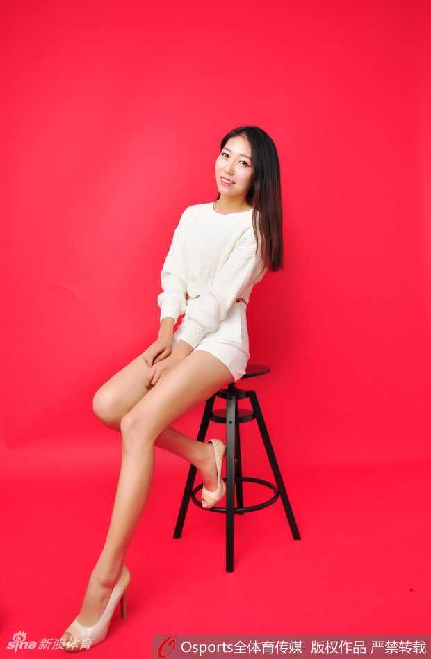 身着亮丽表演服的队员回眸一笑，动感的舞台装与她灿烂的笑容相得益彰，尽显青春活力