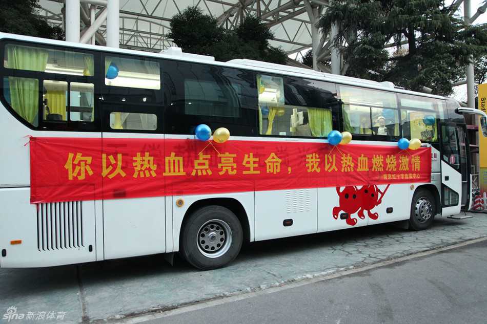 热血汇聚五台山,爱心温暖小轩轩 一辆喷绘着爱心标志的南京红十字血液中心献血车静静停靠在五台山体育馆外,车身标语在夜色中格外醒目,邀请过往球迷为生命加油。