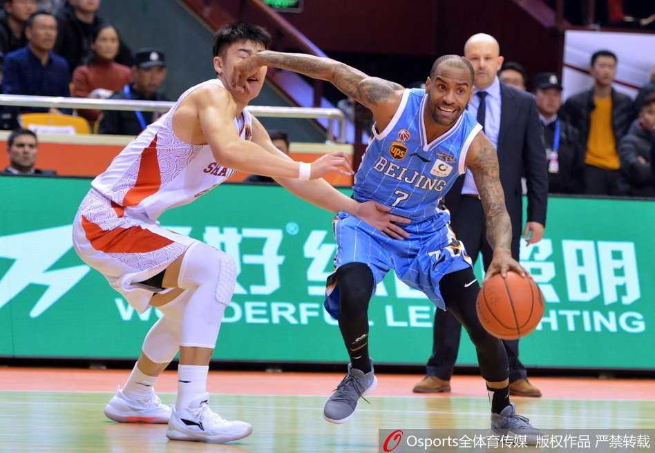 易建联在三人合围中奋力跃起，犹如鹤立鸡群，摘下关键的前场篮板，眼中满是对胜利的渴望。