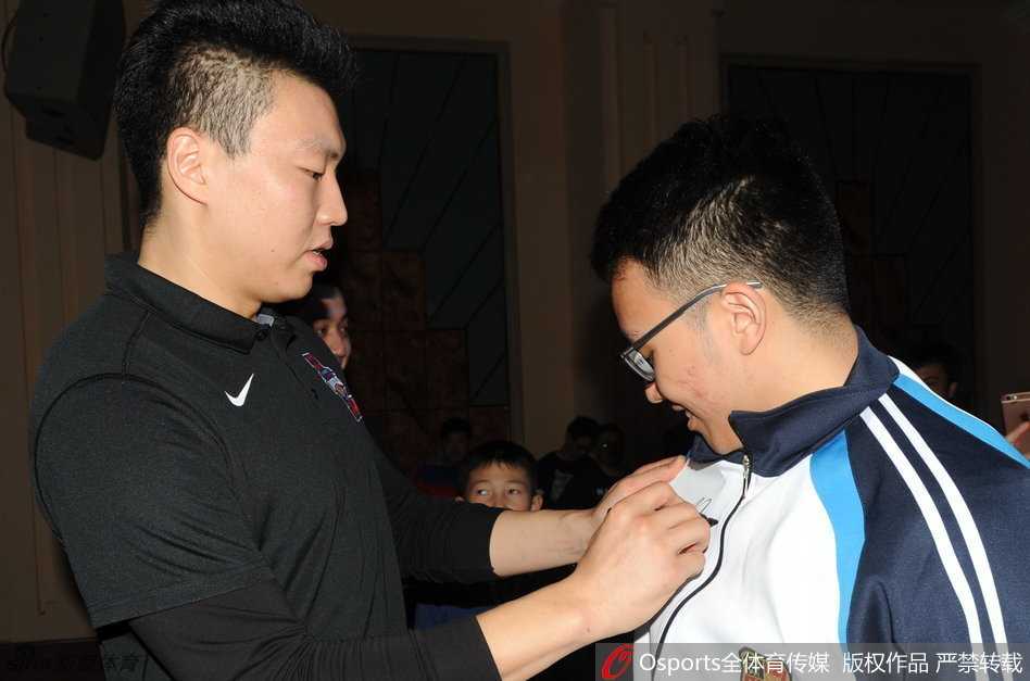 一名男生兴奋地撩起校服衣摆，李根弯着腰，单膝微曲，以一种平等的姿态在洁白的校服上郑重留下自己的名字，这不仅仅是一个签名，更像是一份关于坚持的承诺。