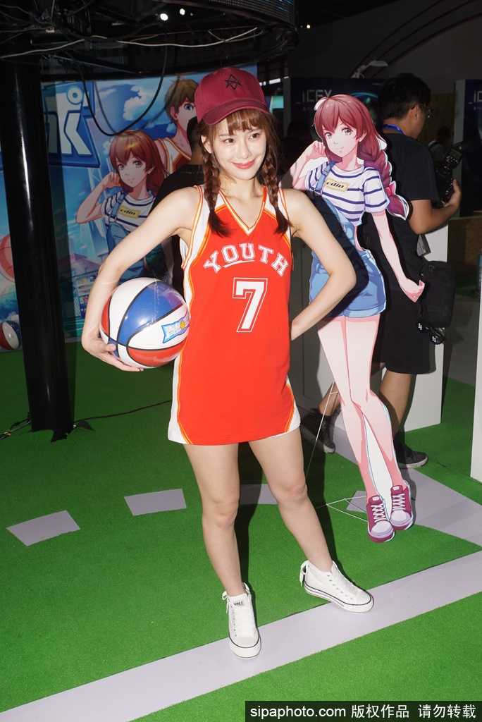 身着火红篮球战袍的靓丽精灵，在展台中央跳跃定格，仿佛从NBA嘉年华中走出的活力女神