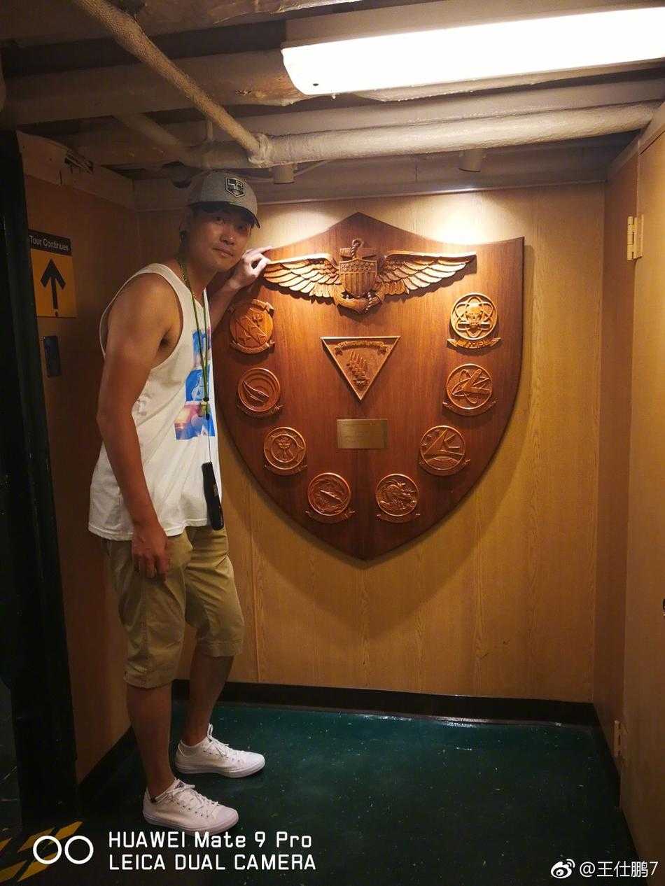 夜幕降临，煤气灯街区的霓虹灯逐一亮起，王仕鹏在一家餐厅的露台上享受晚餐，身后是熙熙攘攘的人群和维多利亚风格的建筑，充满活力。