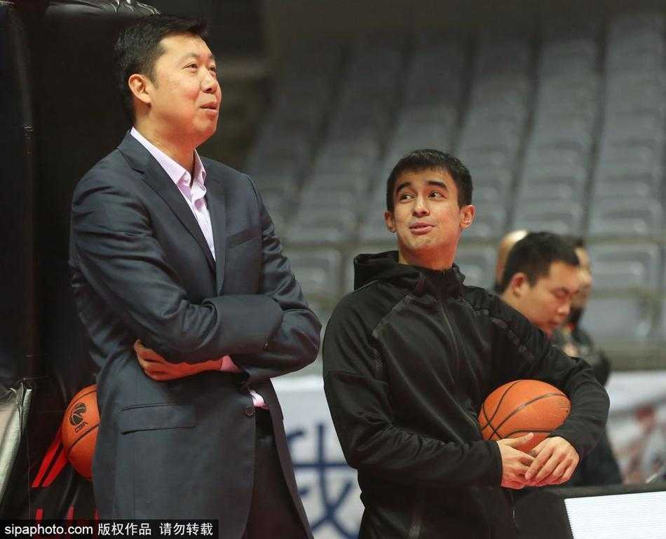 面对身边人的交谈，大郅转过头认真倾听，眉宇间透出一股英气，即使在嘈杂的训练馆里，他依然保持着那份独特的儒雅与从容。