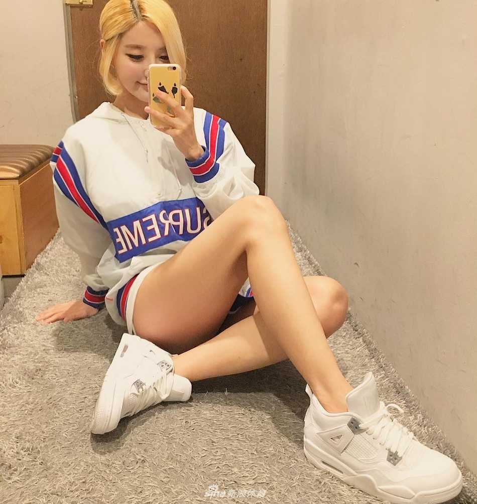 画面中的Soda轻轻倚靠在墙边，看似随意的姿势却难掩其俏皮气质，一双美腿在光影交错下显得格外修长，与脚上那双经典配色的AJ球鞋构成了一幅让无数男生女生都心动的画面。