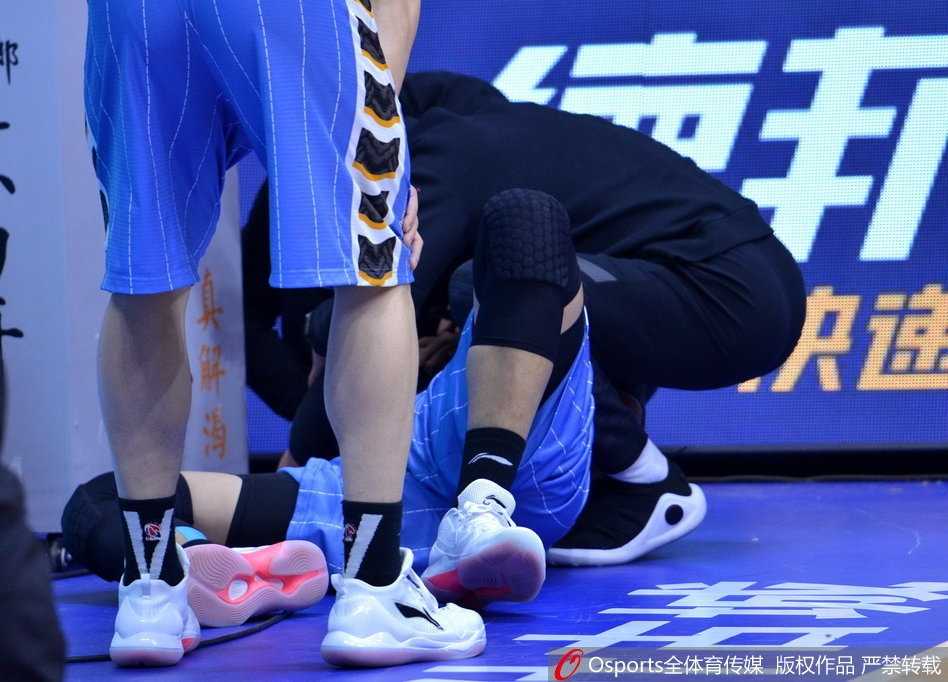 翟晓川坐在场边接受治疗，右手腕缠着厚厚的冰袋，表情依旧痛苦，但目光始终没有离开赛场。