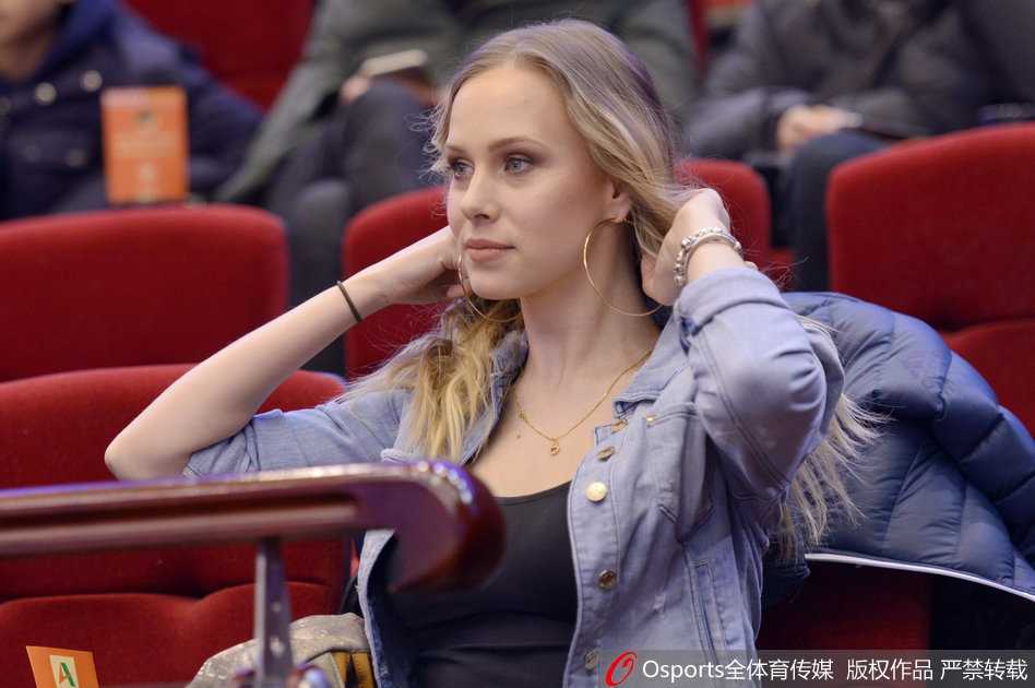 她将福字轻轻举过肩头，那抹中国红与她金色的秀发在光影中交织成画，笑容明媚而灿烂，仿佛此刻她手中握着的不仅是一张福字，更是对全家人在中国生活美满的殷切祈福。