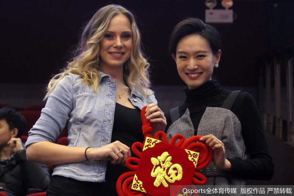 在球场璀璨灯光的映照下，她微微侧首，手中的福字宛如一抹东方胭脂，点缀在她白皙的面庞旁，那不经意间流露的嫣然一笑，足以融化北方冬夜的寒冰。