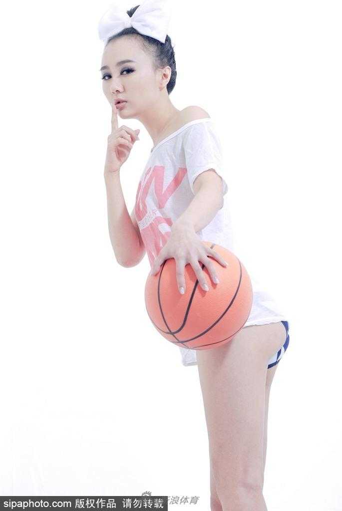 白莫菲侧身坐在篮球上，身体曲线展露无遗，眼神深邃而迷离，带着一丝成熟的妩媚与自信。