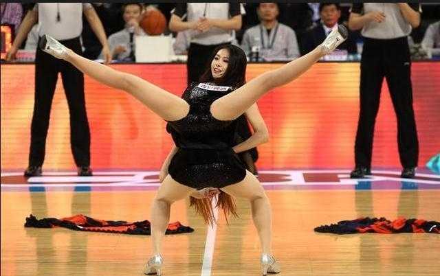 篮球宝贝惊艳一字马的背后,是你看不到的台下十年功 一位篮球宝贝在完成一字马动作后,低头微笑,眼神温柔而充满感染力,她身后的队友们还在尽情舞动,整个画面定格了活力与柔美的完美结合,让人感受到篮球宝贝的热情。