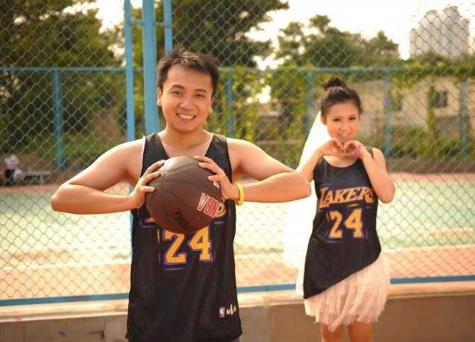 新娘坐在新郎宽厚的肩膀上，两人同时做出投篮的姿势，手中的篮球即将脱离指尖，仿佛要将这份幸福像绝杀球一样，稳稳地投入篮筐。