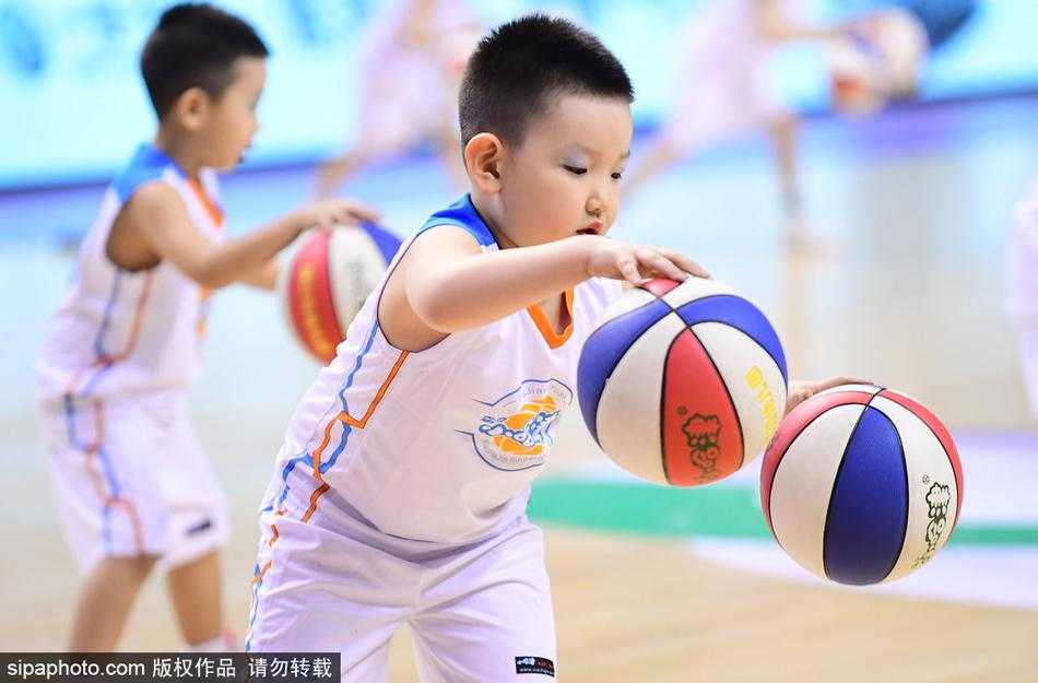 镜头拉近，一位领舞的小男孩双手同时运球，表情酷酷的，仿佛在告诉全世界：未来篮球巨星就是我！身后的队友们则排着整齐的队形为他加油。
