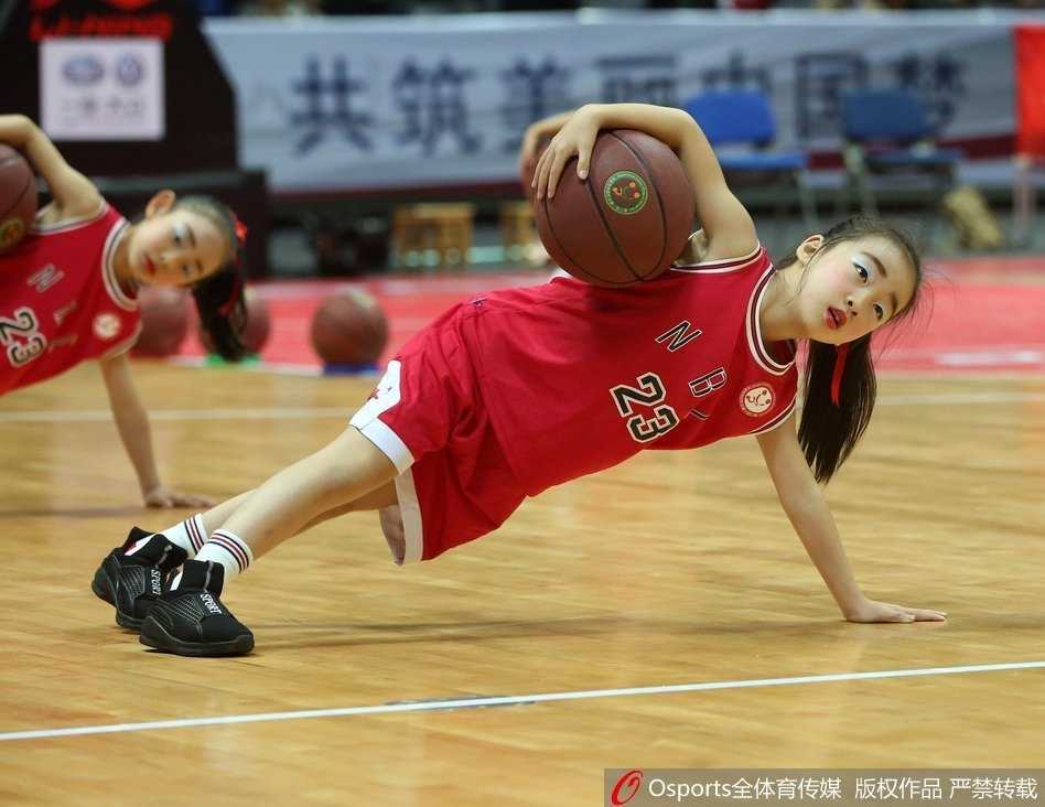 一名小球员在人群中灵巧地将球挑起，准备进行过人，周围防守球员的眼神中充满了惊讶与无奈，画面充满了童趣与竞技的张力。