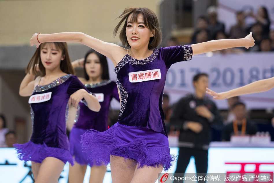 几位篮球宝贝蹲在地上围成一圈，似乎正在进行上场前最后的战术讨论与互相加油鼓劲。她们的妆容精致，眼神中充满了对即将开始的表演的期待与坚定。