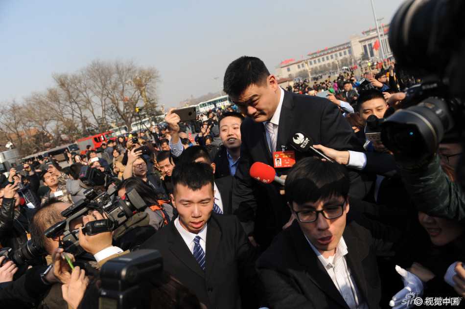 身高出众的姚明在人群中如同移动的高塔，他眉头微锁，面对记者围堵显得有些无奈，只能加快步伐向会场走去