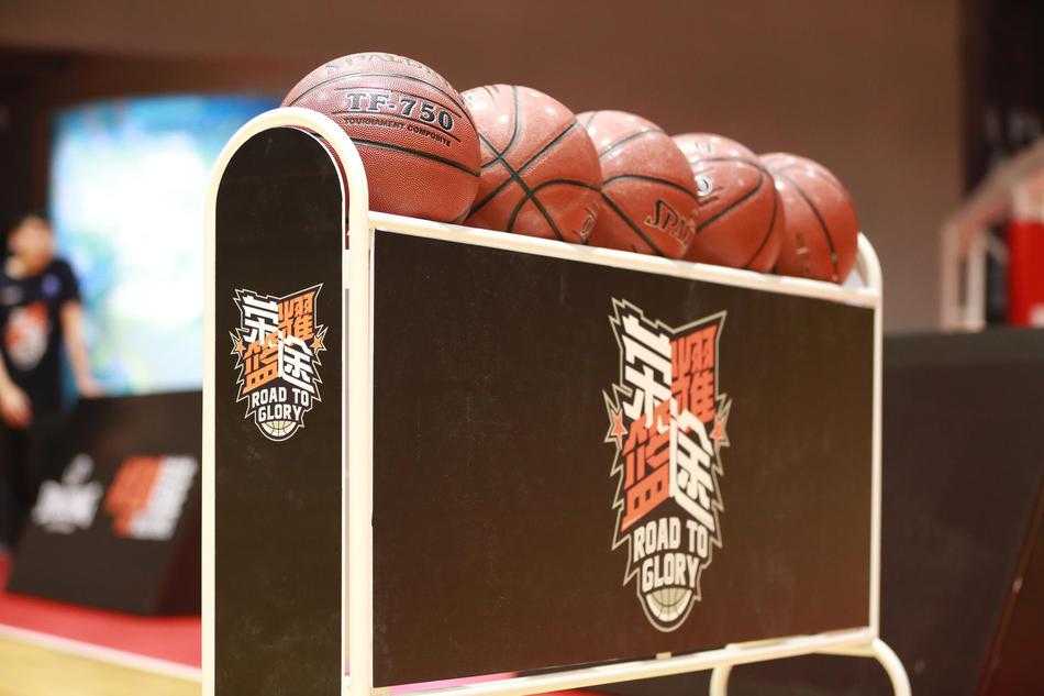 荣耀篮途深圳站:热血激战正酣,十四强进军全国总决赛 一位球员在空中双手灌筐,身体呈反弓形,球衣因剧烈的动作而猎猎作响,篮架下的队友和对手都仰头注视,时间仿佛在这一秒静止。