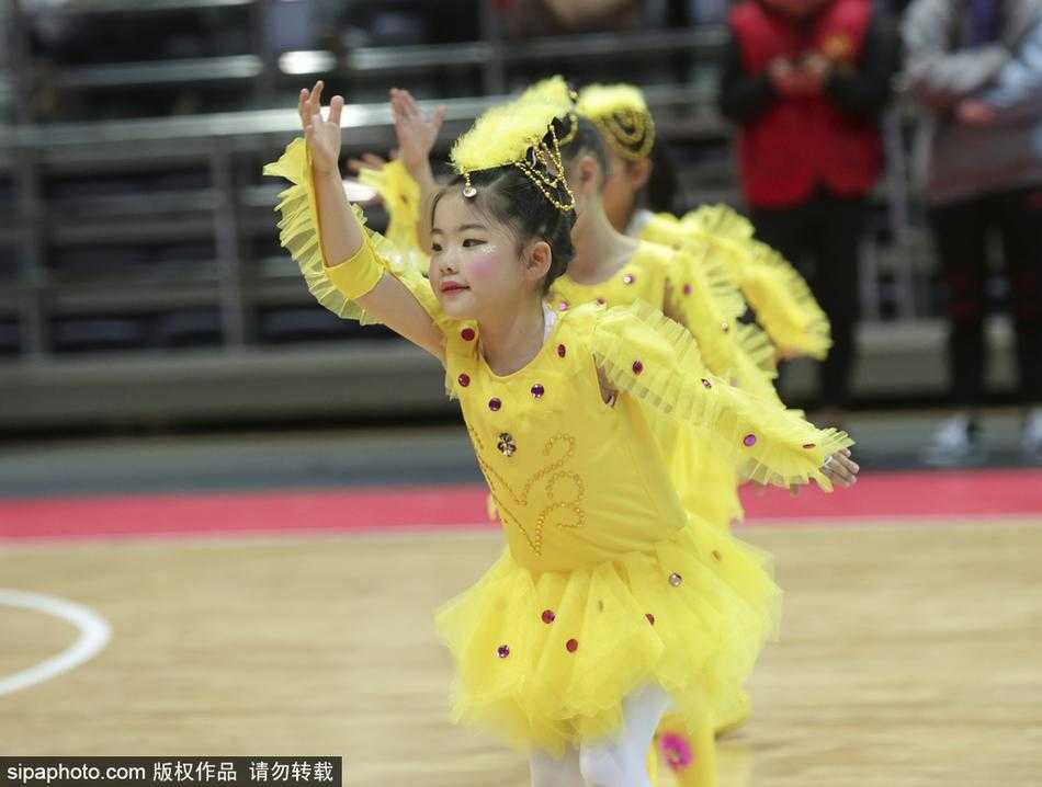 一群穿着红色肚兜和短裤的萌娃啦啦队队员，在CBA赛场上整齐地排成队列，她们肉嘟嘟的小手紧握彩球，稚嫩的脸上写满了认真与专注。