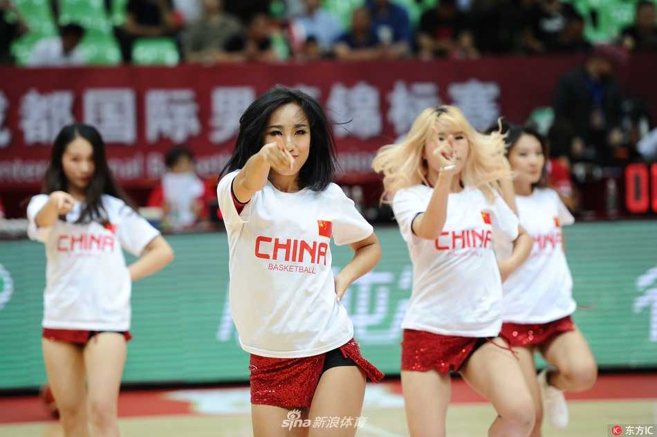 蓉城夏夜篮球火 红队激战安哥拉 宝贝热舞燃爆全场 近景镜头下,一位扎着高马尾的啦啦队员笑容灿烂,她手中的花球仿佛闪烁着星光,汗水滑落脸颊,却丝毫不影响她投入的表演。