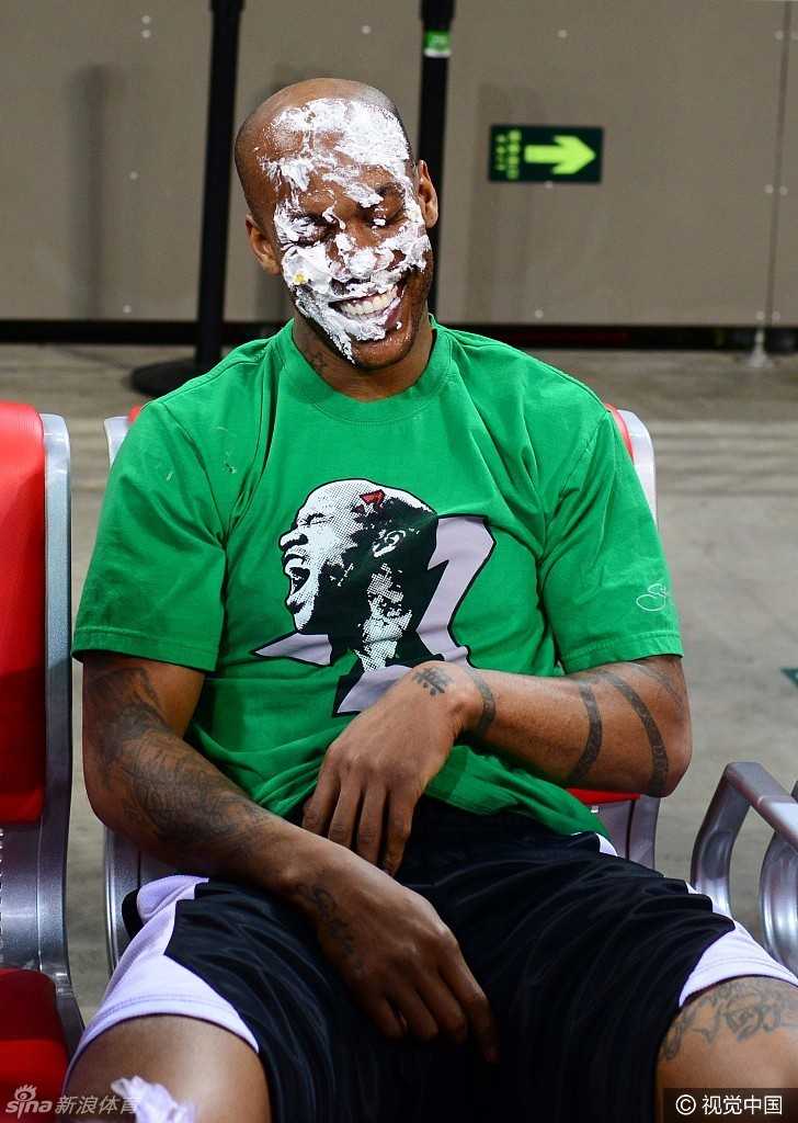 面对多人的围攻，这位满脸奶油的朋友虽然处于劣势，但依然笑得开怀，享受着这多对一的甜蜜攻击。