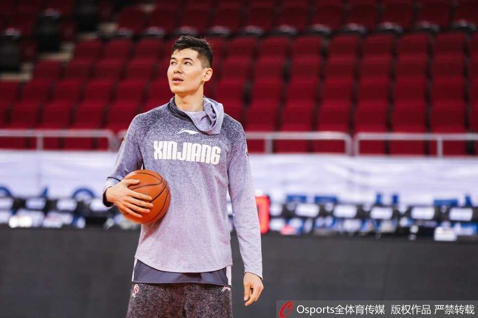 西热力江的沉思时刻:铁血悍将的赛场内外 西热力江在助教的协助下进行拉伸训练,肌肉线条分明,神情专注而放松,展现了职业球员对身体管理的极致追求