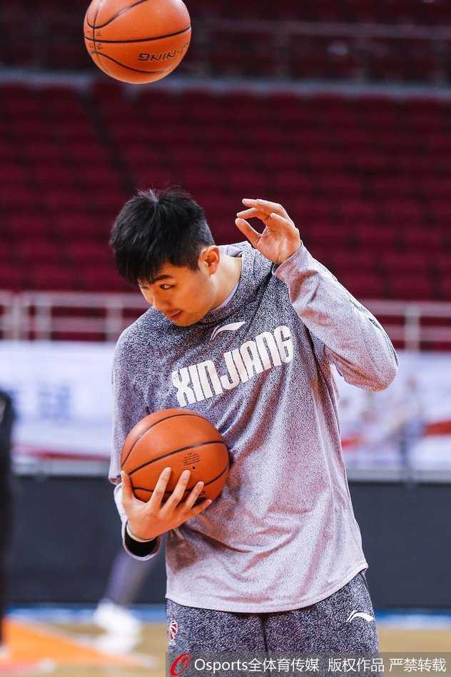 西热力江的沉思时刻:铁血悍将的赛场内外 西热力江双手紧握训练服,置于身后,抬头挺胸望向训练馆的天花板,仿佛在进行赛前的最后冥想与自我激励