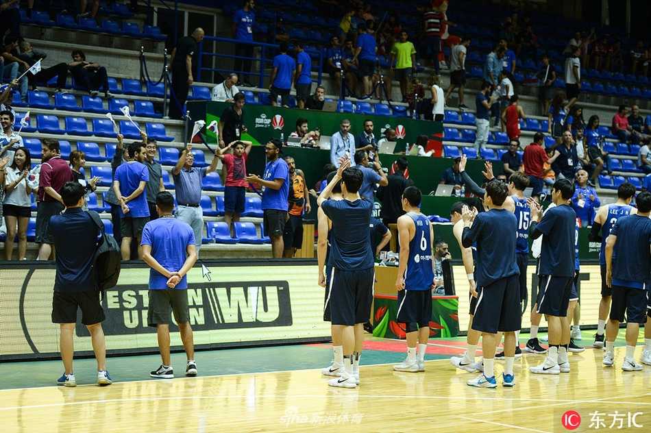 日本队华裔球员张本天杰在底角接到传球，面对韩国队的补防球员，果断起跳出手三分，皮球在空中划出高高的弧线。