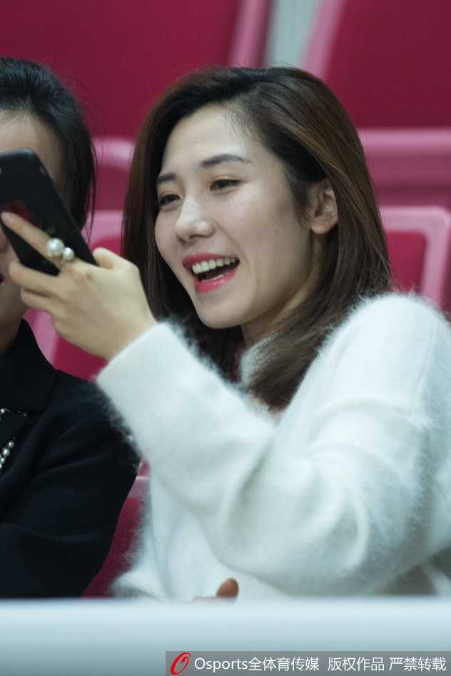 中场休息时，这位美女球迷对着镜头露出了略显羞涩却又十分甜美的笑容，背景是正在热身准备的篮球宝贝。