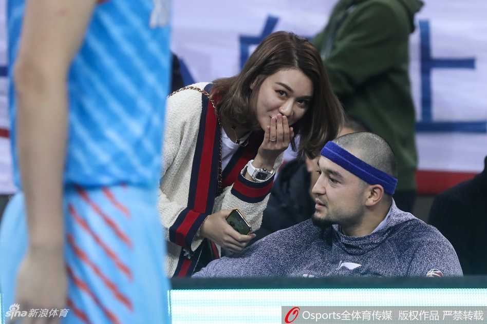 赛场温情与硬汉本色:二〇一八季CBA京疆大战侧记,李根妻子场边观战引热议 新疆队替补席后的看台上,李根妻子面带微笑为球队的精彩进球鼓掌,身边是热情的北京球迷,她显得优雅又得体。