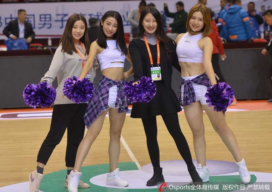 全景镜头下的篮球宝贝表演，她们在偌大的篮球场上列队舞动，虽然与球员相比身材娇小，但凭借整齐划一的动作和强大的气场，成功将整个赛场变为自己的主场