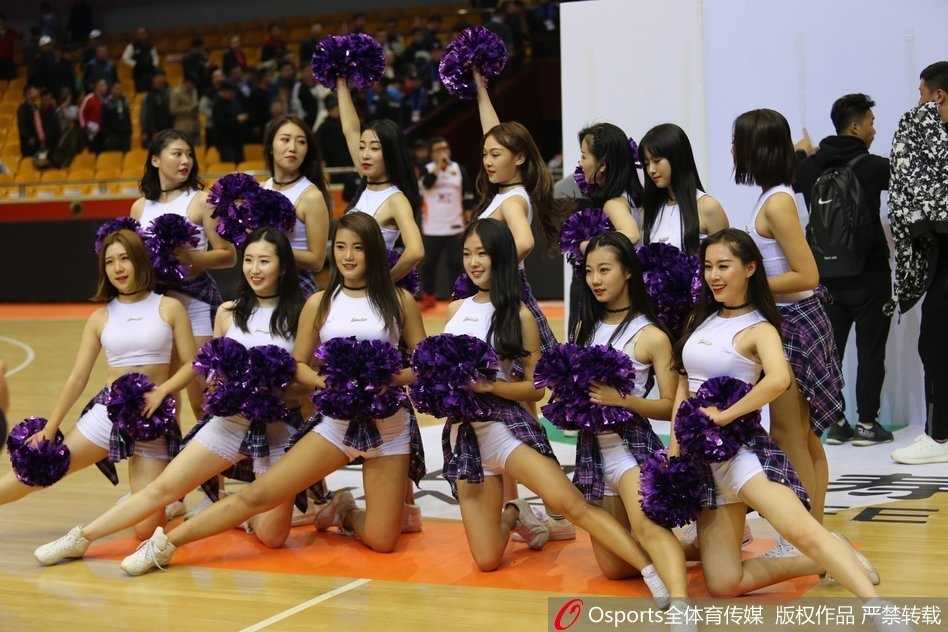 山东篮球宝贝们摆出表演的结束造型，她们身姿挺拔，笑容甜美，身后的看台上坐满了热情的观众，人声鼎沸的赛场此刻仿佛都成了她们的背景板