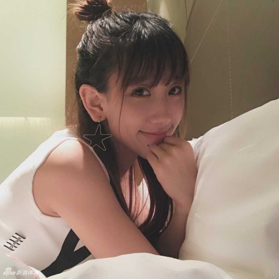 在聚光灯下，小娜自信地展示着啦啦队道具，身后的光影衬托出她优雅的身姿和迷人的气质