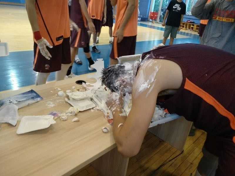 赵继伟生日蛋糕拍脸仪式 周琦一旁偷笑被捕捉 在众人起哄声中,一块蛋糕精准地拍在赵继伟脸上,瞬间奶油飞溅,一旁的周琦探出半个脑袋,咧着嘴偷笑,眼神里满是
