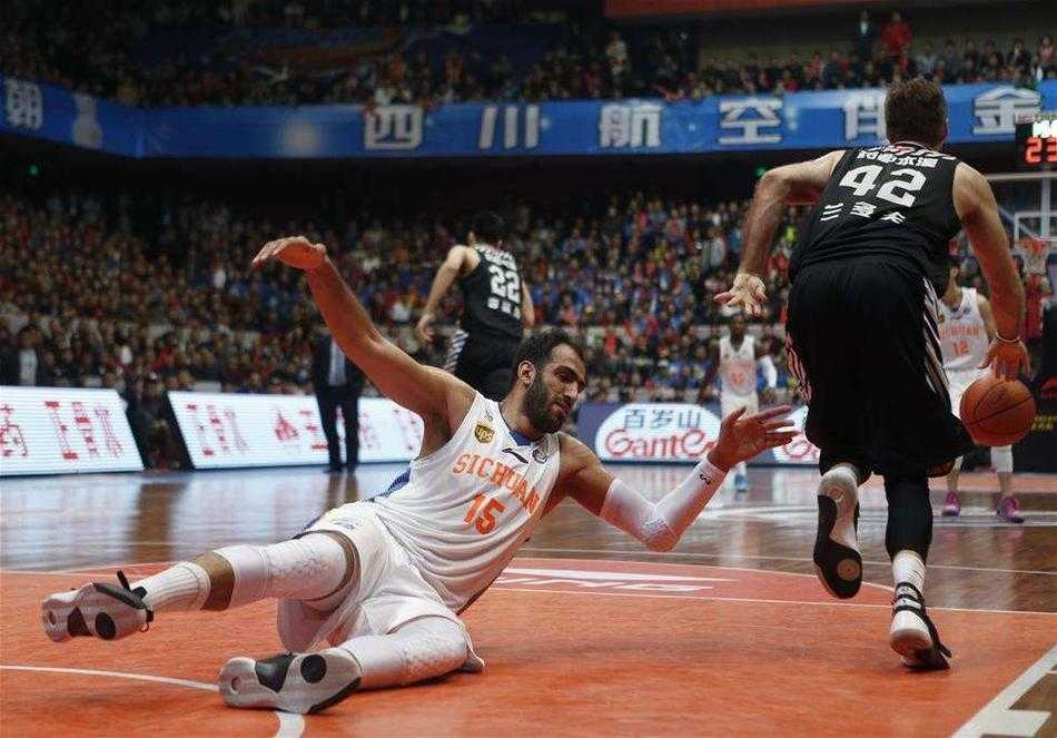 一名运动员在比赛中被对手撞倒，整个人飞了出去，但他在落地瞬间仍试图用手支撑，眼神紧盯前方