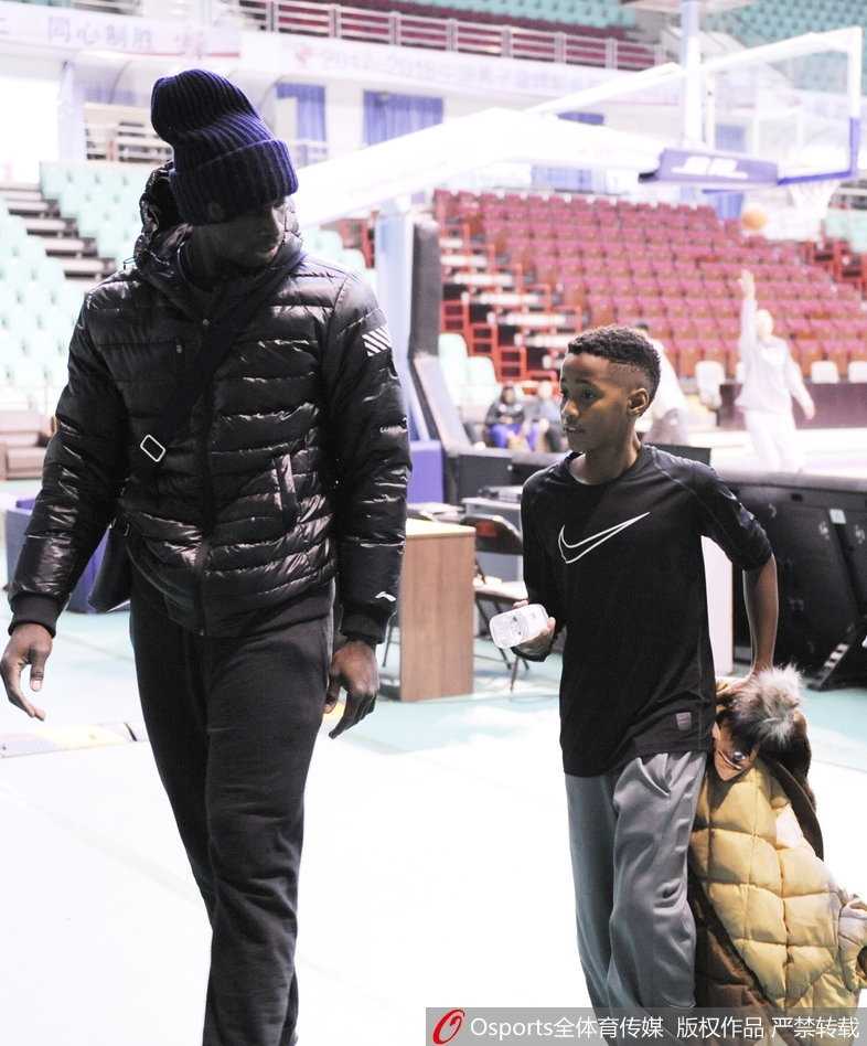 巴斯单手将儿子高高举起，让他摸高，父子俩笑容灿烂