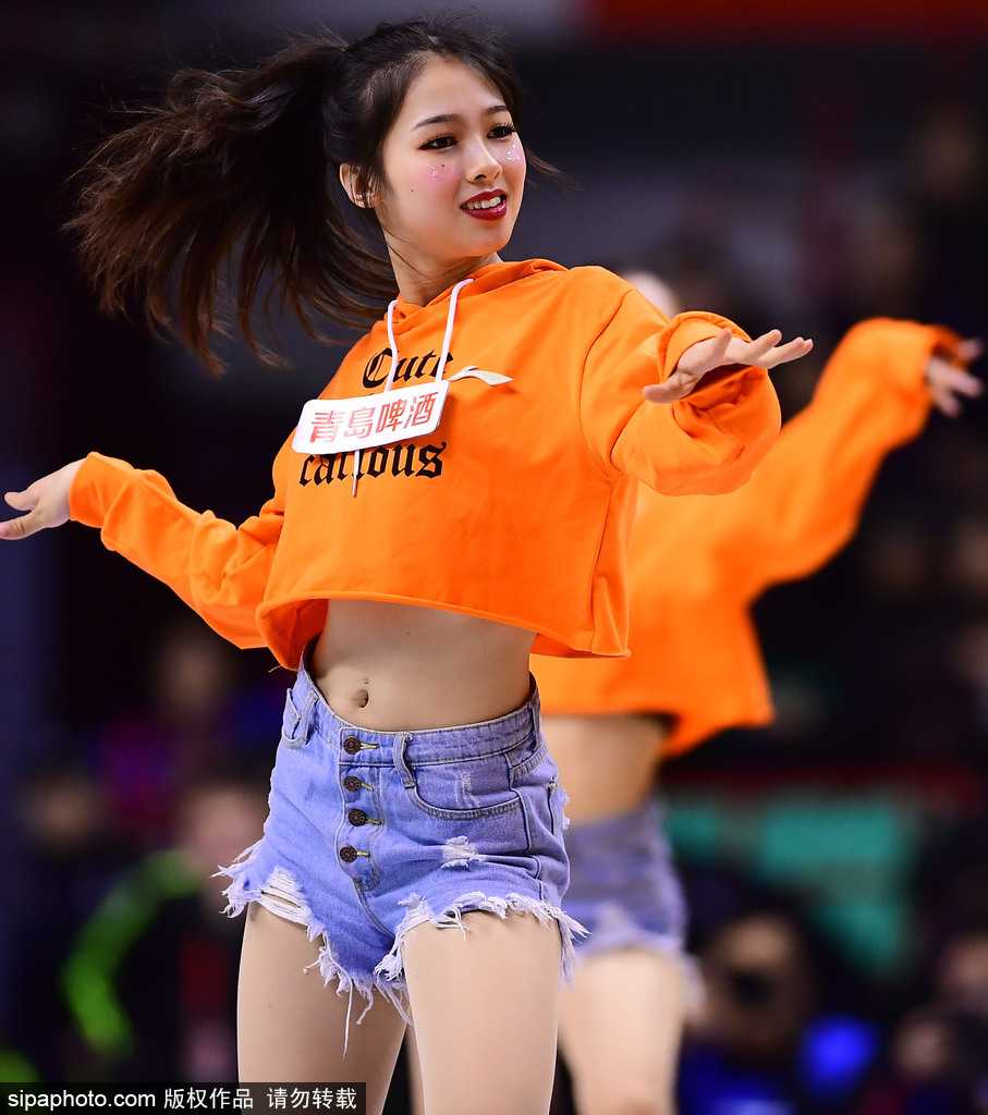 篮球宝贝们身着红白相间的劲装，马尾辫随着动感的鼓点有力甩动，她们张开双臂，用最灿烂的笑容迎接入场观众，仿佛冬日里的一把火。