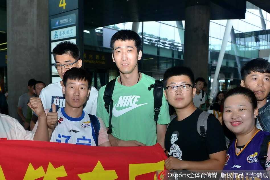 丛明晨弯腰与小球迷合影毫无球星架子，年轻小将眼中闪烁着冠军的光芒