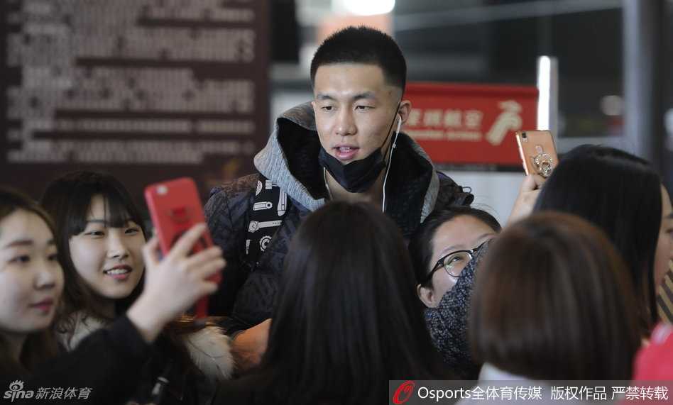 郭艾伦被里三层外三层的球迷团团围住，他微微低头为身前的小球迷在球衣上签名，嘴角挂着标志性的腼腆笑容