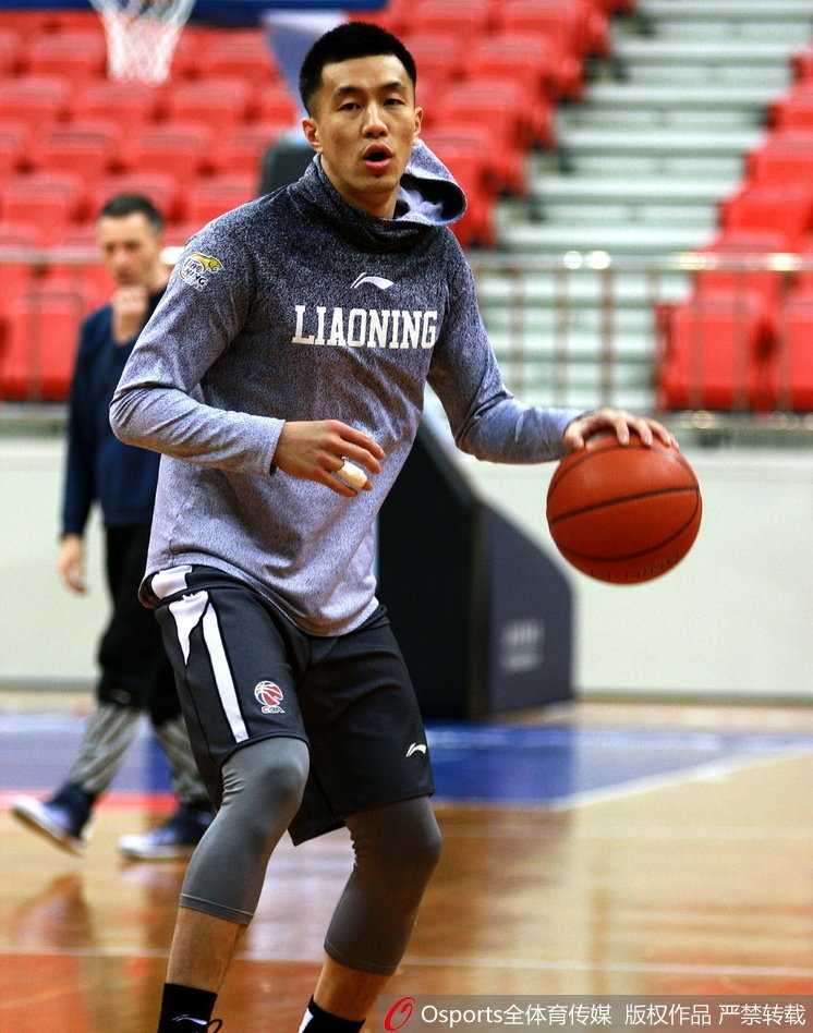 赵继伟在训练间隙与年轻队员交流战术，表情认真而又不失亲和力，旁边的助教也加入了讨论，训练馆里充满了积极向上的学习氛围。