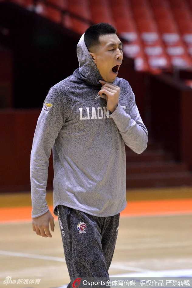 郭艾伦单手控球，眼神坚毅地望向远方，仿佛在思考当晚比赛的战术，身后的训练背景虚化，更凸显了他的专注力。