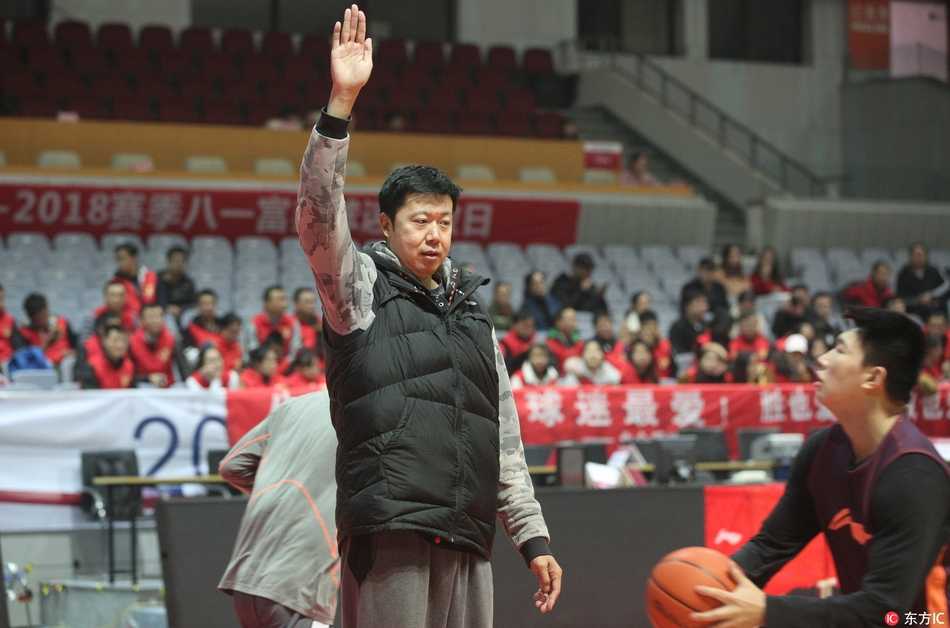 大郅在对抗训练中轻舒猿臂，面对防守球员抛射出手，场边的球迷们纷纷举起手机记录这一瞬间。