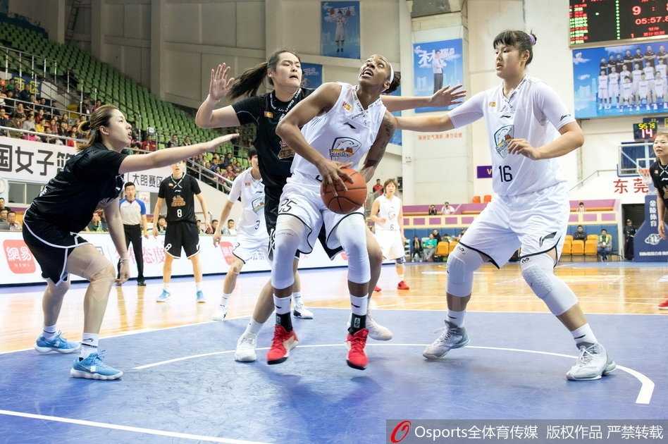 鏖战东莞:江苏女篮客场逆转广东的经典一战 广东队外援约翰逊在三人包夹下强行上篮,她肌肉紧绷,表情坚毅,篮球在空中划过一道弧线,防守球员的手掌几乎封到了她的脸上,展现出极强的个人能力和对抗中的冷静。