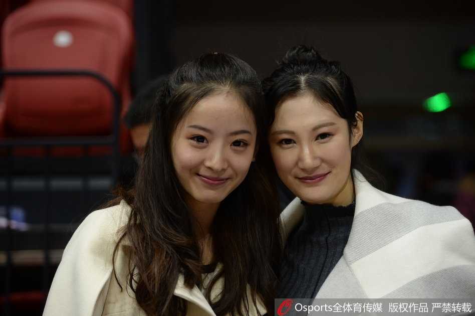 孙桐林妻子戴着时尚的墨镜，面容精致，在人群中显得格外突出，她正专注地看着场内，似乎正在为丈夫的每一次成功防守而暗自鼓劲。