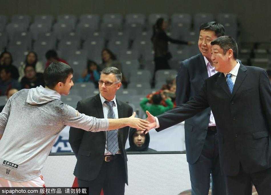 铁血军魂犹在,大郅温情暖甬城:八一迎战同曦赛前特写 王治郅双手背后,神情专注地注视着场上的八一队年轻队员,身后是正在热身的对手,他的身影显得沉稳而坚定,宛如定海神针。