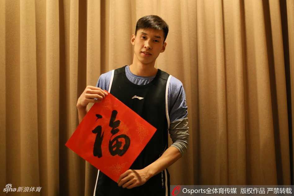 铁血军魂迎新岁 八一男篮拜大年!雷蒙领衔众将镜头前送暖意 画面中的雷蒙剑眉星目,嘴角微扬,彼时刚成为球队核心的他眼神中既有年轻人的锐气,又带着几分过年的喜气。他手中的红色围巾与背景的节日装饰交相辉映,仿佛在诉说着这个东北大男孩在宁波的拼搏与成长,也代表着球队在新一年里渴望红红火火的愿景。